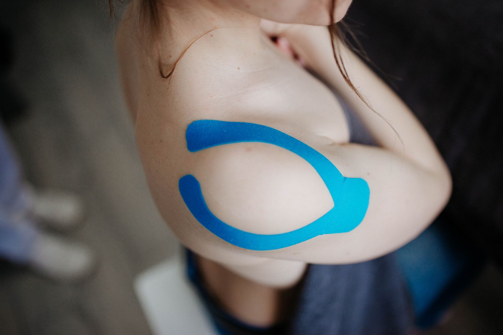 Kék kineziotape felhelyezve a váll területére